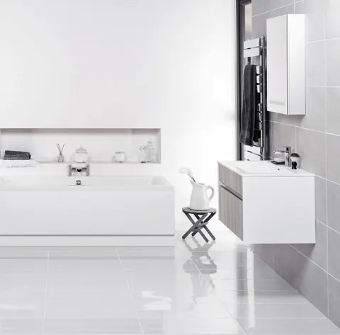 White bathroom with a built-in bathtub, a wall-hung vanity and grey wall tiles